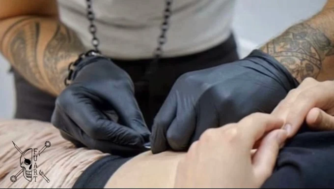 Professionelles Piercing Studio Glanz & Stich. Piercer bei der Arbeit mit sterilen Handschuhen